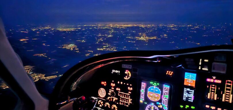 Nachtflug über eine Stadt im Helikopter