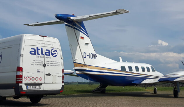 Ein Transporter vor einem Flugzeug auf dem Rollfeld