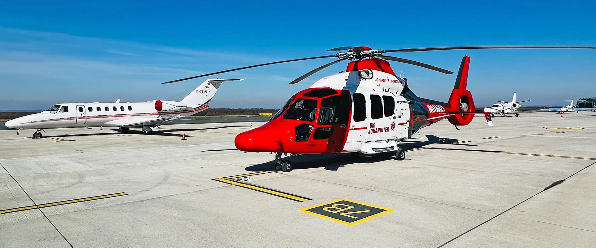 Helikopter und Flugzeuge auf dem Rollfeld